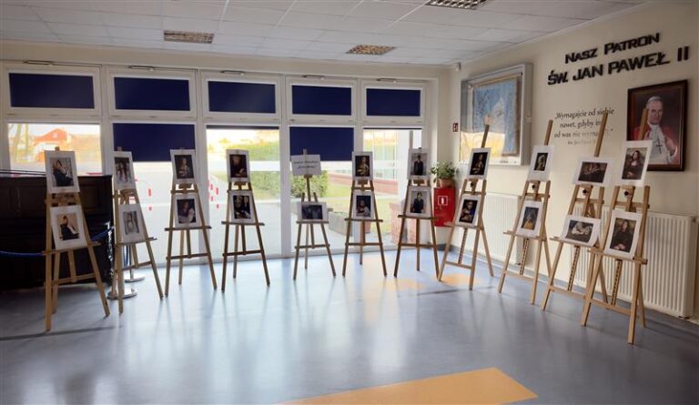 Sztalugi z wystawionymi pracami w holu szkoły