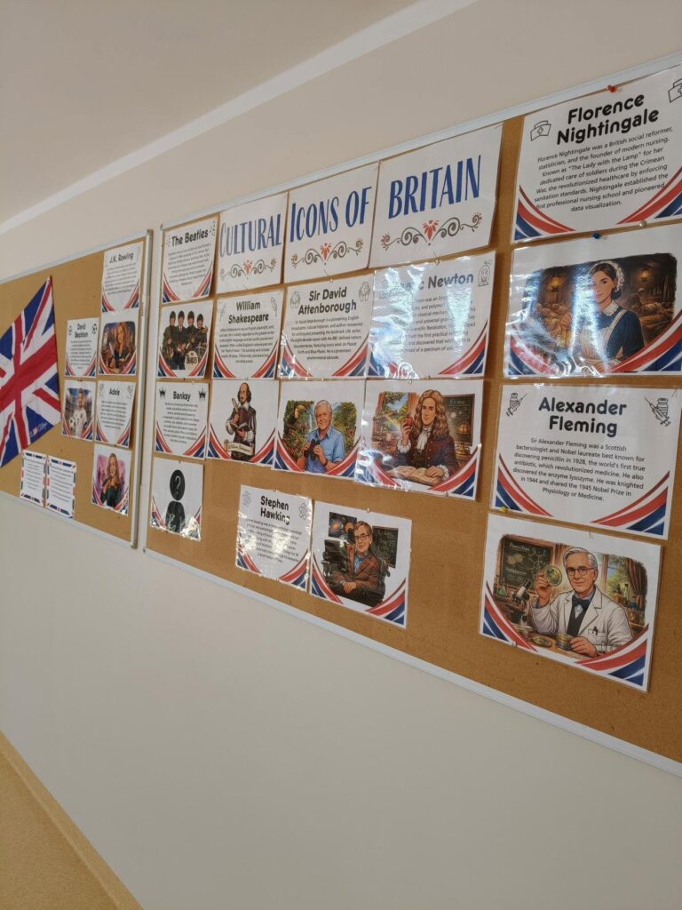 Gazetka szkolna na ścianie pt. „Cultural Icons of Britain”, prezentująca plakaty znanych postaci, takich jak William Shakespeare, Isaac Newton, Florence Nightingale i Alexander Fleming, ozdobiona motywami brytyjskiej flagi.